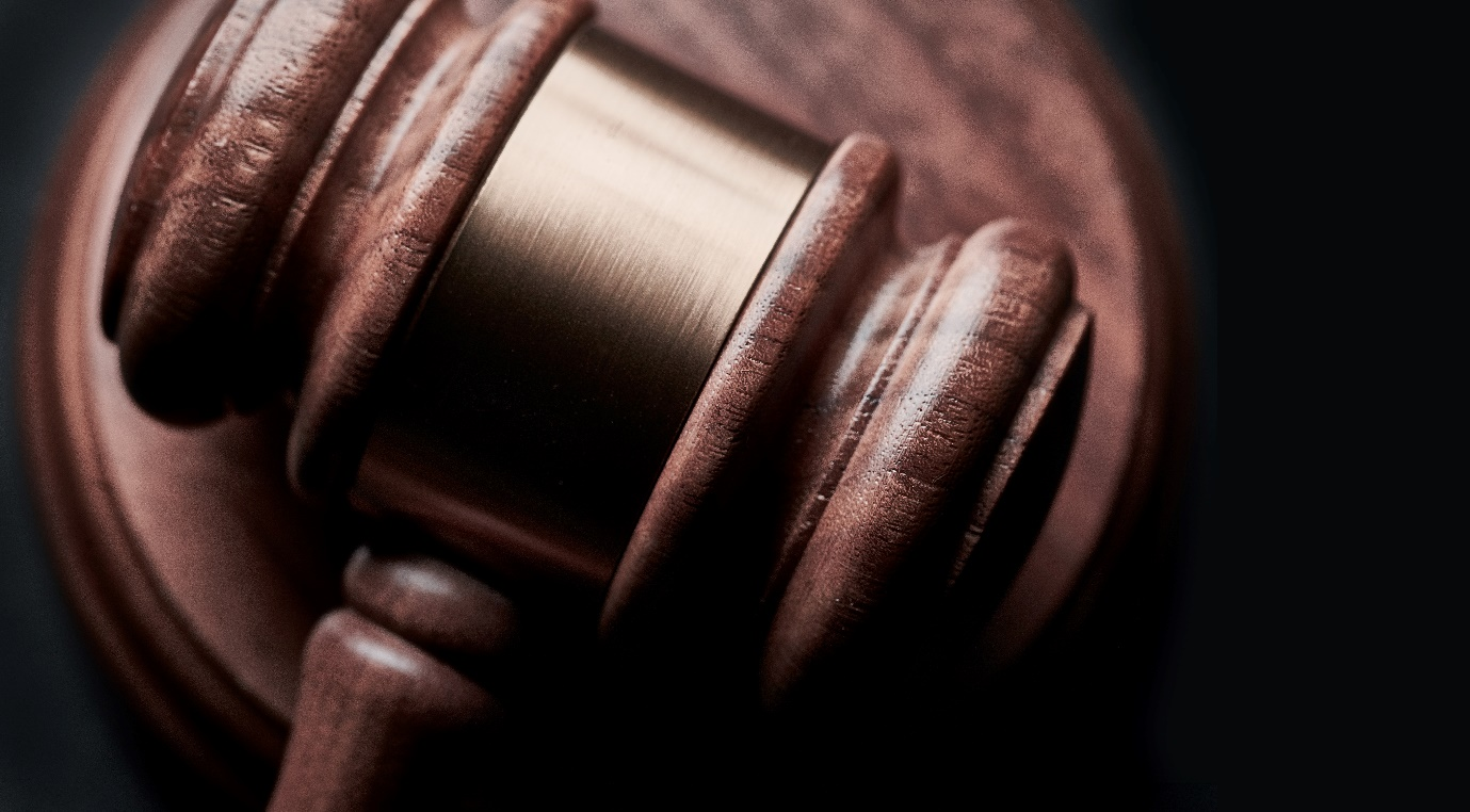 A brown gavel lying on a sound block