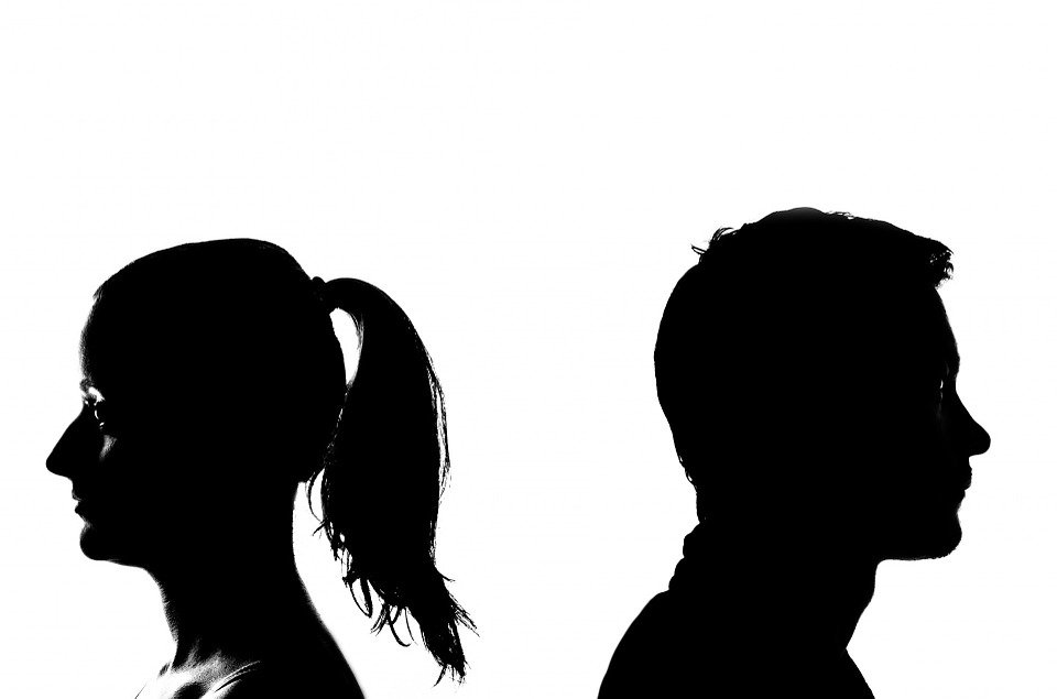 Silhouette of man and woman standing apart